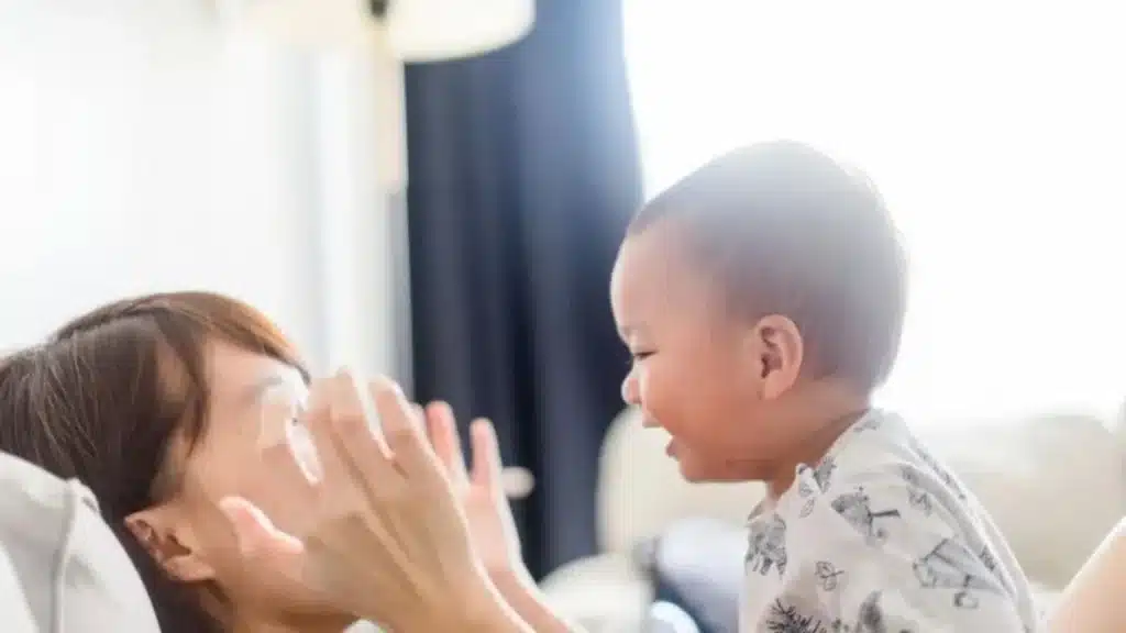 Baby playing peek-a-boo and erupting into a contagious smile.